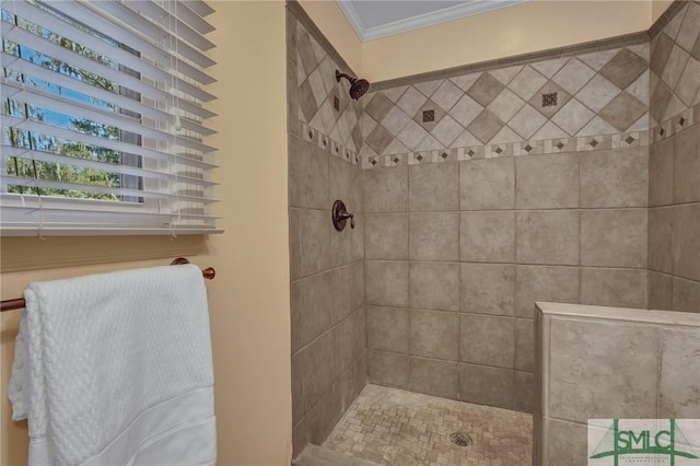 bathroom with a tile shower and ornamental molding