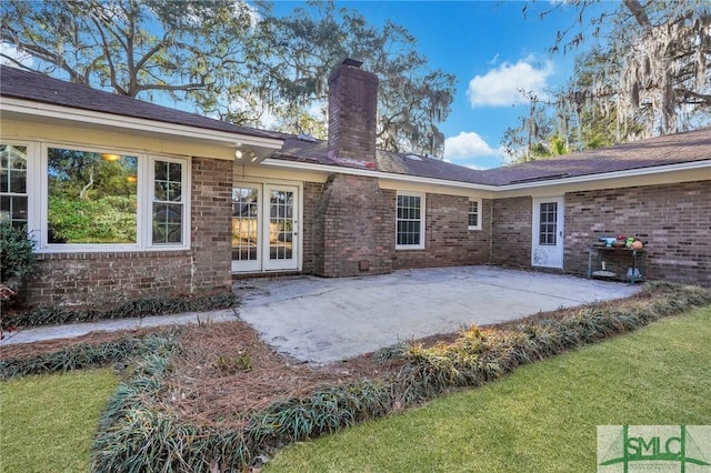 rear view of house with a patio and a lawn