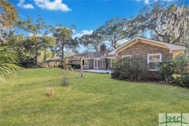 back of house with a lawn and a patio area