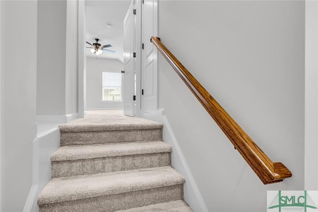 staircase featuring ceiling fan