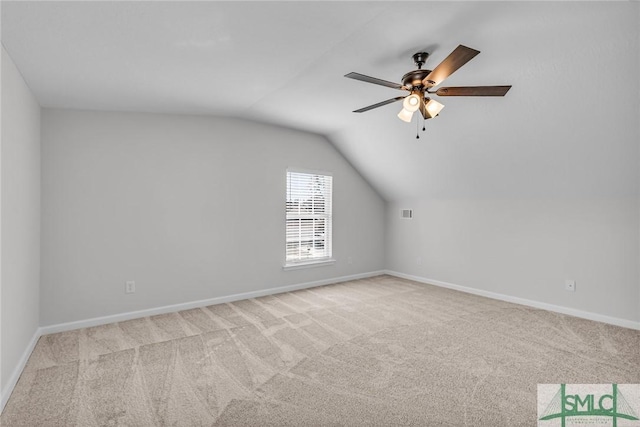 additional living space with vaulted ceiling, light colored carpet, and ceiling fan