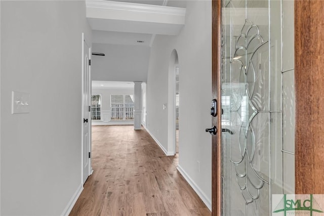 hallway featuring ornate columns and light wood-type flooring