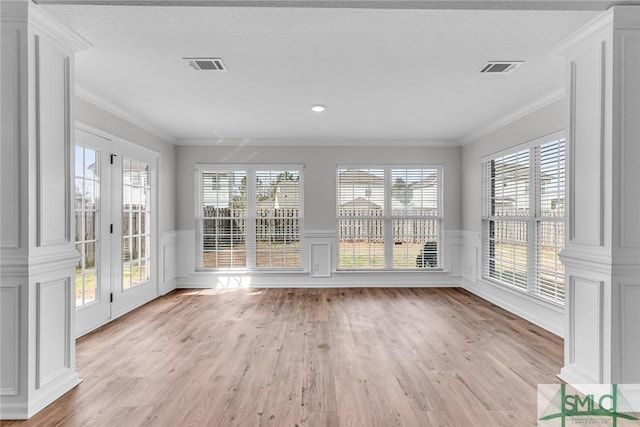 unfurnished sunroom featuring plenty of natural light and decorative columns