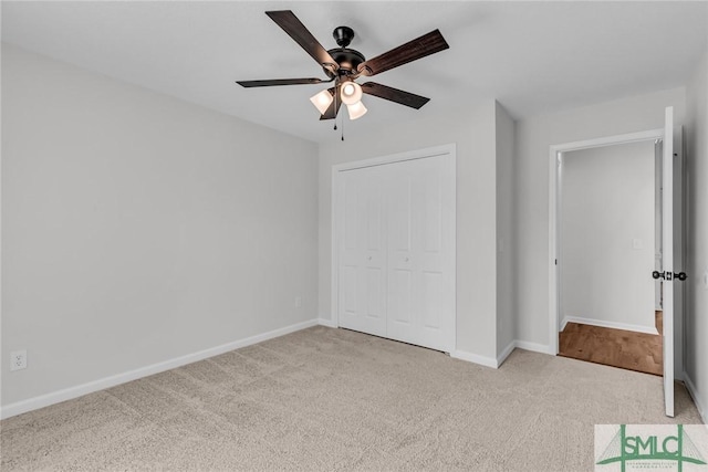 unfurnished bedroom with ceiling fan, light carpet, and a closet