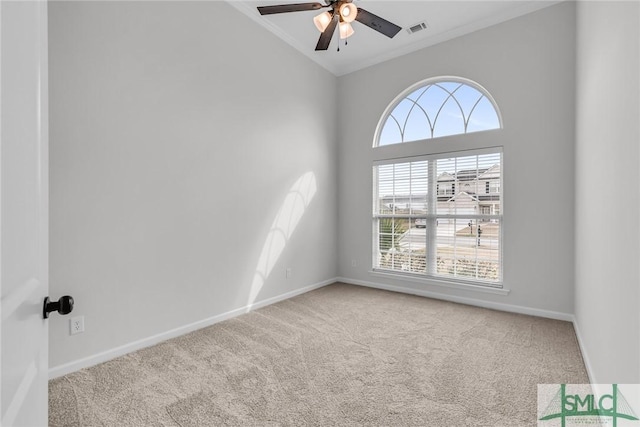 carpeted spare room featuring ornamental molding, lofted ceiling, and ceiling fan