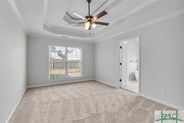 unfurnished room featuring crown molding, light colored carpet, ceiling fan, and a tray ceiling