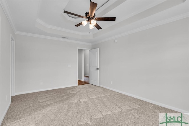 carpeted empty room with crown molding, ceiling fan, and a raised ceiling