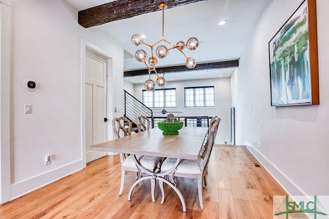 dining room featuring beamed ceiling, a chandelier, and light hardwood / wood-style flooring