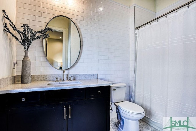 bathroom featuring vanity, tile walls, and toilet