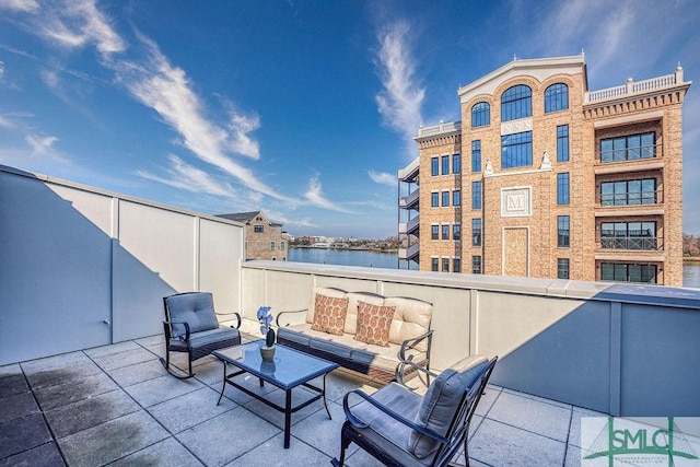 view of patio / terrace featuring a balcony, a water view, and an outdoor hangout area