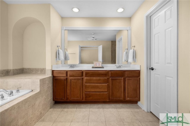 bathroom with vanity, tiled tub, and tile patterned flooring