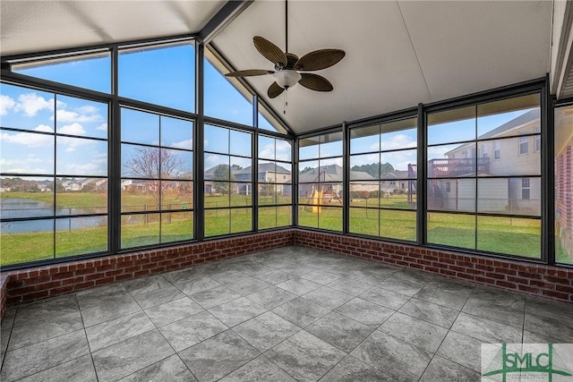 unfurnished sunroom with a water view, vaulted ceiling with beams, and ceiling fan