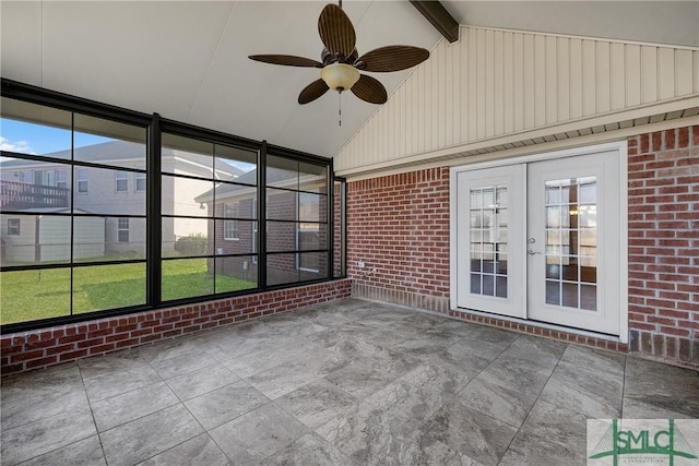 unfurnished sunroom featuring lofted ceiling with beams, ceiling fan, and french doors