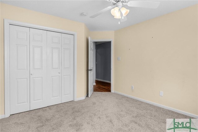 unfurnished bedroom with light colored carpet, ceiling fan, and a closet