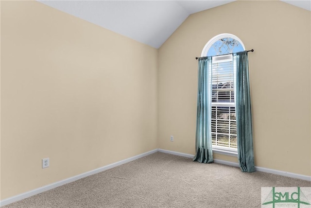 carpeted empty room with lofted ceiling