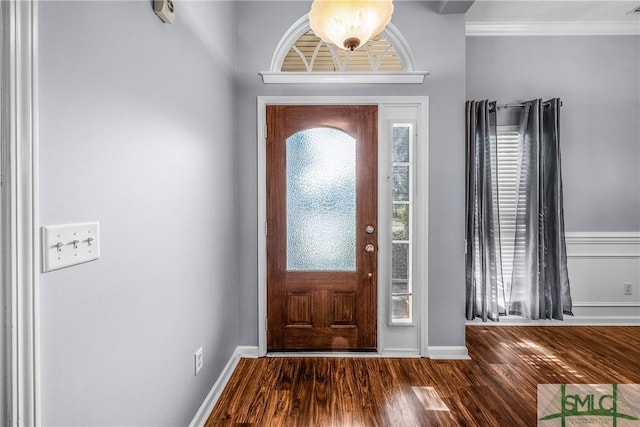 foyer entrance with dark hardwood / wood-style flooring and crown molding