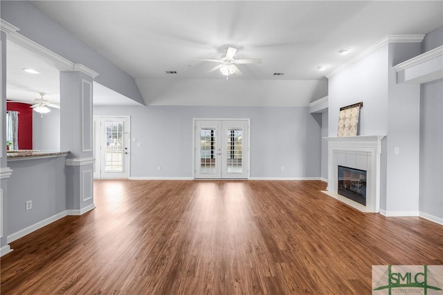 unfurnished living room featuring a fireplace, decorative columns, wood-type flooring, ceiling fan, and french doors