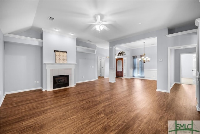 unfurnished living room featuring a tiled fireplace, ceiling fan with notable chandelier, dark hardwood / wood-style flooring, and ornamental molding