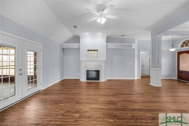 unfurnished living room with a tile fireplace, ceiling fan, dark hardwood / wood-style flooring, vaulted ceiling, and french doors