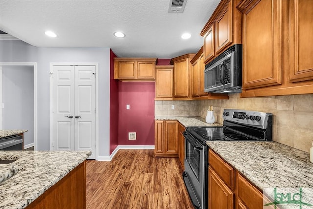 kitchen featuring electric stove, light stone counters, tasteful backsplash, a textured ceiling, and light wood-type flooring