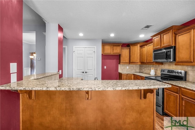 kitchen with appliances with stainless steel finishes, a breakfast bar area, and backsplash