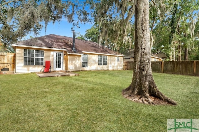 rear view of house with a patio and a yard