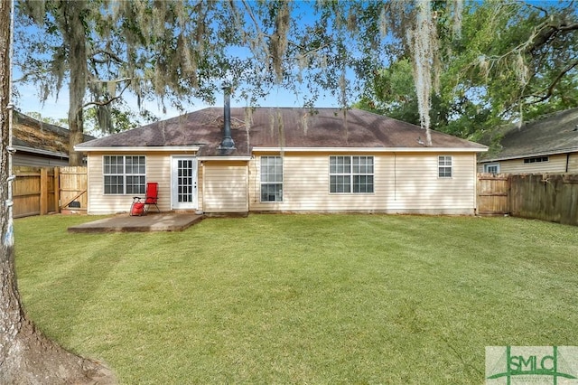 back of house with a patio area and a lawn