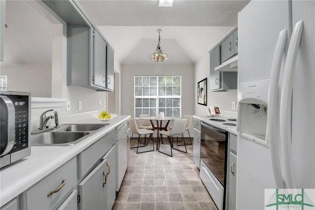 kitchen featuring decorative light fixtures, lofted ceiling, sink, gray cabinetry, and white appliances