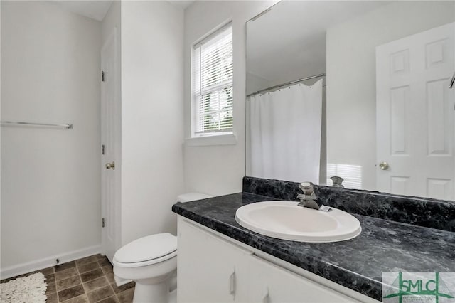 bathroom with tile patterned floors, vanity, toilet, and curtained shower