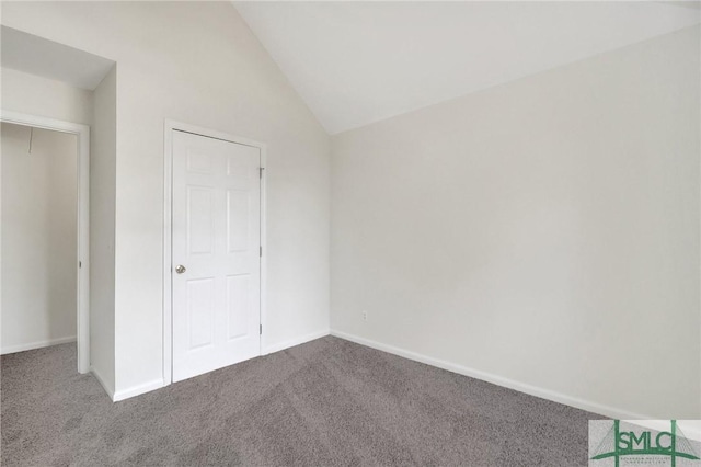 unfurnished bedroom featuring vaulted ceiling and carpet