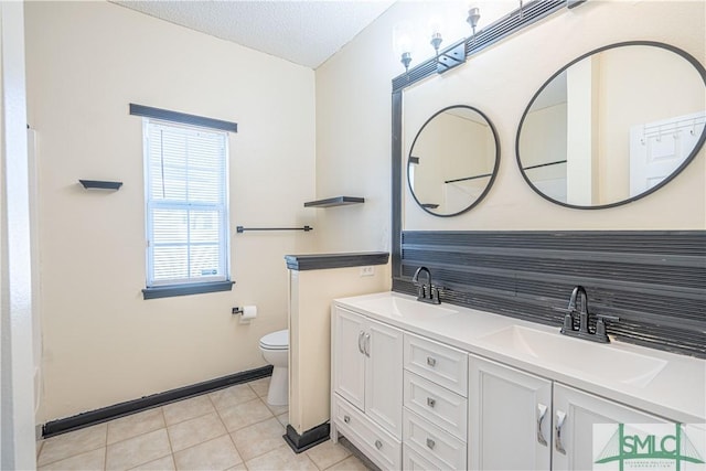 bathroom with vanity, tile patterned flooring, a textured ceiling, and toilet