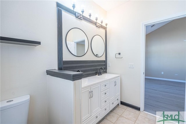 bathroom featuring vanity, toilet, and tile patterned flooring