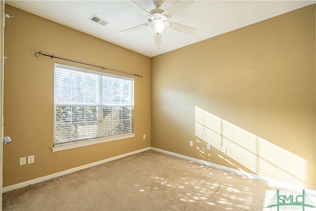 spare room featuring ceiling fan, carpet, and a textured ceiling