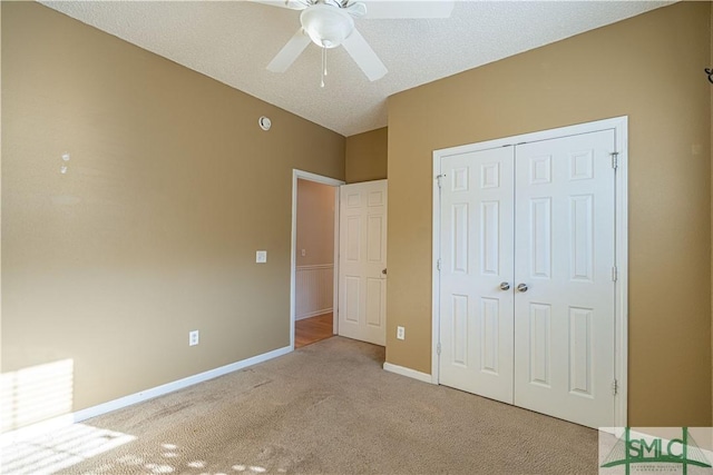 unfurnished bedroom featuring a textured ceiling, light colored carpet, a closet, and ceiling fan