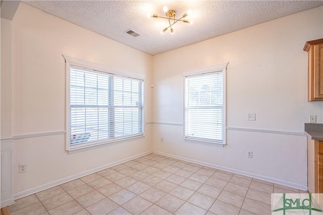 tiled spare room featuring a textured ceiling