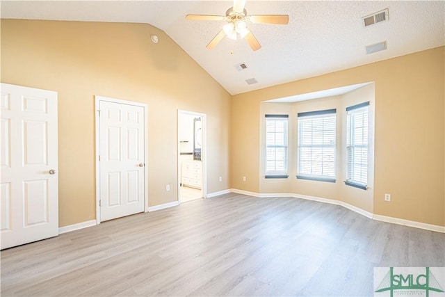 unfurnished bedroom featuring high vaulted ceiling, light hardwood / wood-style floors, ceiling fan, and ensuite bathroom