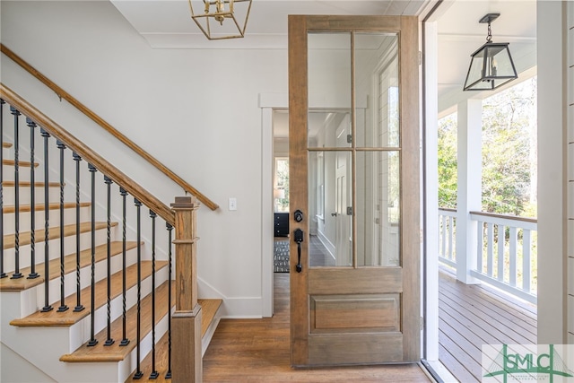 foyer with stairway, baseboards, and wood finished floors