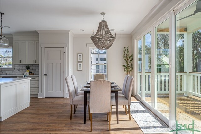 dining area with ornamental molding and wood finished floors