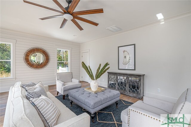 living room with visible vents, ceiling fan, baseboards, and wood finished floors