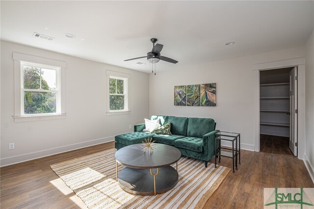 living room with recessed lighting, visible vents, baseboards, and wood finished floors