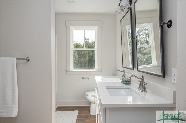 full bath with wood finished floors, a sink, toilet, and baseboards