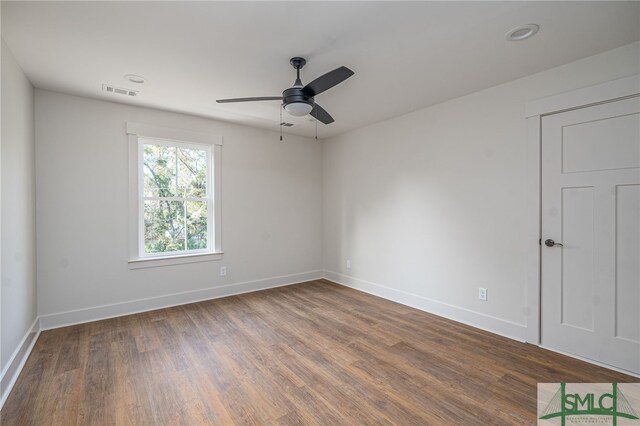 spare room featuring ceiling fan, wood finished floors, visible vents, and baseboards