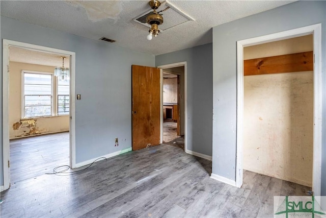 unfurnished bedroom with ceiling fan, light hardwood / wood-style floors, and a textured ceiling