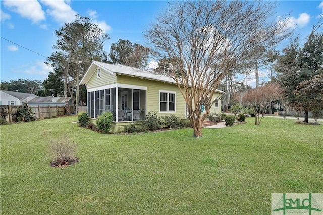 view of yard featuring fence and a sunroom