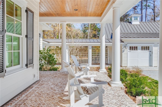 sunroom / solarium featuring wooden ceiling and ornate columns