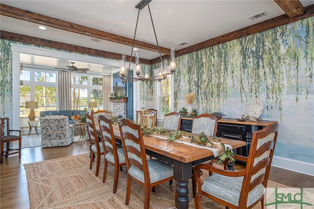 dining area with beam ceiling, hardwood / wood-style flooring, and ceiling fan with notable chandelier