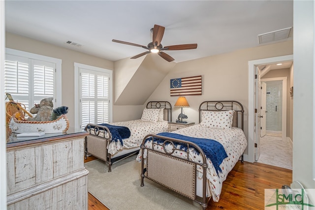 bedroom with ceiling fan, wood-type flooring, and lofted ceiling