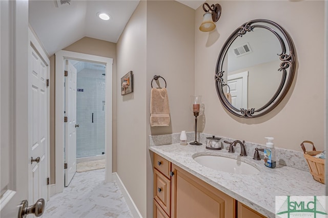 bathroom with vanity, a shower with shower door, and vaulted ceiling