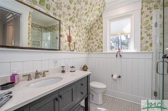 bathroom with vanity, crown molding, a shower with shower door, and toilet