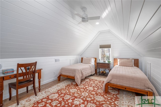 bedroom featuring wood ceiling, wood walls, vaulted ceiling, and light wood-type flooring